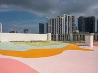 colorful playground on the rooftop with urban buildings in the background and a street sign at one end