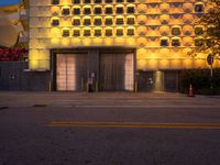 an orange building with windows on either side of it that is lit up at dusk