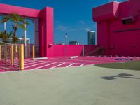 the building is bright and vibrant pink in color, the architecture is as if by the outside world