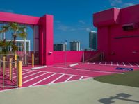 the building is bright and vibrant pink in color, the architecture is as if by the outside world