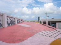 an empty parking lot has been painted red and yellow in the middle of a cloudy day