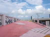 an empty parking lot has been painted red and yellow in the middle of a cloudy day