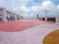 an empty parking lot has been painted red and yellow in the middle of a cloudy day