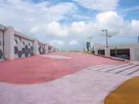 an empty parking lot has been painted red and yellow in the middle of a cloudy day