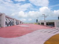 an empty parking lot has been painted red and yellow in the middle of a cloudy day