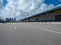 an empty lot with an empty parking lot in the background and clouds in the distance