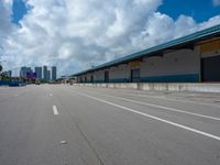 an empty lot with an empty parking lot in the background and clouds in the distance