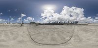 a 360 - 360 photo of a road through the desert area of an airport with a sky and clouds in the background