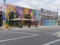 the street is empty and has been painted with a colorful wall design and graffiti by a painter