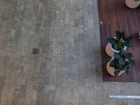 a view down on the floor, and plants in vases on tables at the end of the wooden walk