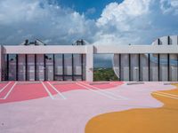 the colorful painted ground has a building in the background with a sky background and clouds