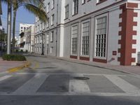 there is a white and brown brick building along the street with red and white stripe