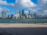 a man riding his bike near the water by himself on a windy day in miami