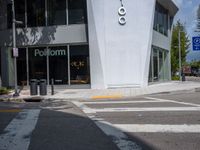 a car stopped at an intersection while a man rides his bike in the distance by