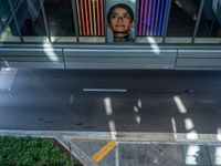 a woman looking out of a window at a street sign and building with colorful lights