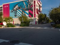 a zebra crossing the street in front of a colorful building on a sunny day in miami