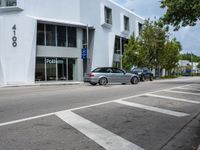 a silver car is driving on the road in front of a building or restaurant that reads'999 '