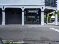 a small business in a city on the street corner with signs on it that read,'heritage henge '