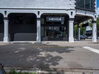 a small business in a city on the street corner with signs on it that read,'heritage henge '