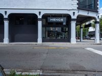 a small business in a city on the street corner with signs on it that read,'heritage henge '