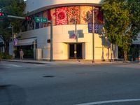 a street scene with focus on the corner and a traffic light on it's pole