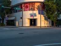 a street scene with focus on the corner and a traffic light on it's pole