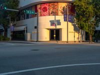 a street scene with focus on the corner and a traffic light on it's pole