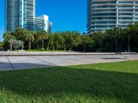 this concrete park features a bench in front of tall buildings and plants surrounding the space