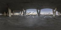 this is an image of a city park with concrete floors and columns around it at dusk