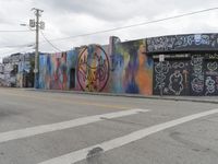 a row of buildings that have been painted on the side of them by graffitiists