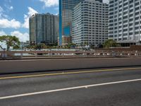 the city skyline is visible in this view from an overpassed bridge with lots of buildings