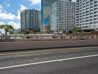 the city skyline is visible in this view from an overpassed bridge with lots of buildings