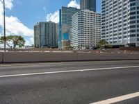 the city skyline is visible in this view from an overpassed bridge with lots of buildings