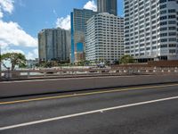 the city skyline is visible in this view from an overpassed bridge with lots of buildings