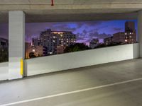 an empty parking garage has the city lights on at night, all painted white and purple