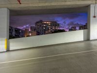 an empty parking garage has the city lights on at night, all painted white and purple