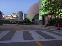 this empty intersection has a large glass dome lit up in green for a nice night