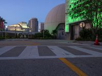 this empty intersection has a large glass dome lit up in green for a nice night