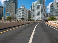 this is a picture of the empty freeway in the city with many skyscrapers in the background