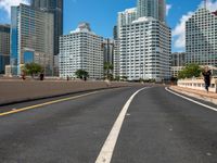 this is a picture of the empty freeway in the city with many skyscrapers in the background