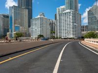 this is a picture of the empty freeway in the city with many skyscrapers in the background