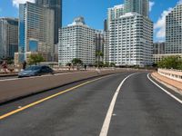 this is a picture of the empty freeway in the city with many skyscrapers in the background