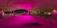 a panoramagraph image of an open building that appears to have some purple lights on