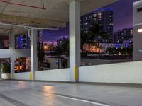 a view of a busy city street at night from an underground parking garage space, with a blue light from above