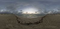 the sea on a sandy beach is shown in this fish - eye lens image,