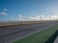 a bus is travelling on an empty highway with clouds behind it in the distance,