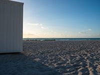 a couple of doors are on a beach next to the ocean in the sunshines