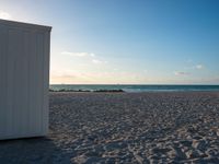 a couple of doors are on a beach next to the ocean in the sunshines