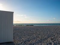 a couple of doors are on a beach next to the ocean in the sunshines