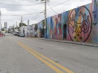 an empty street in front of a colorful mural on the wall with the word i love san written